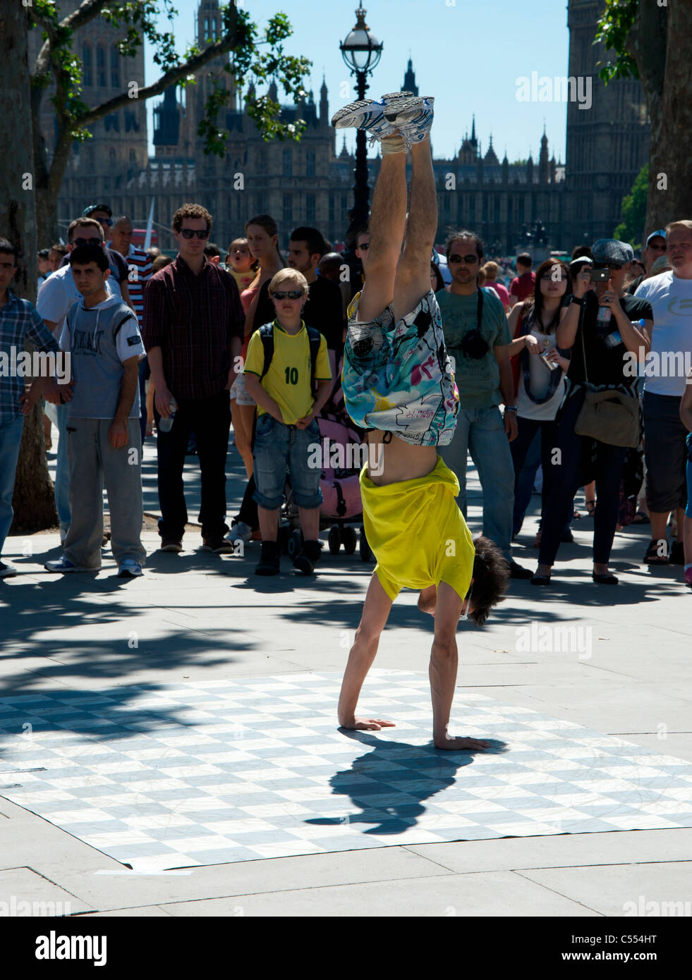 Street performer does handstand in front of crowd Stock Photo