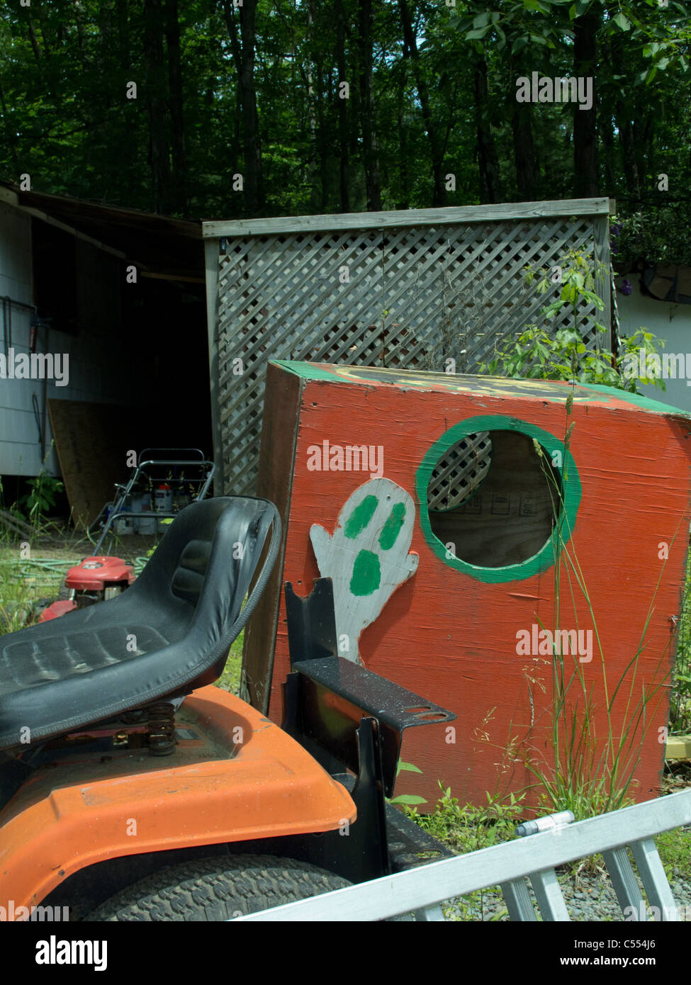 close up of small lawn lawn tractor and wood box with painted ghost Stock Photo