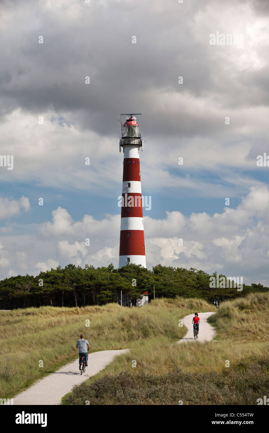 Holland, Ameland Island, Wadden Sea Islands. Unesco World Heritage Site. Hollum, Lighthouse. People on bicycle on beach road. Stock Photo