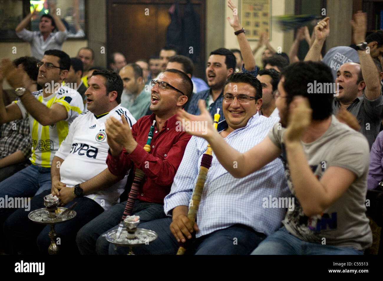 Fenerbahce fans cheering while watching the Turkish Superlig 2011 final on TV in Istanbul, Turkey Stock Photo