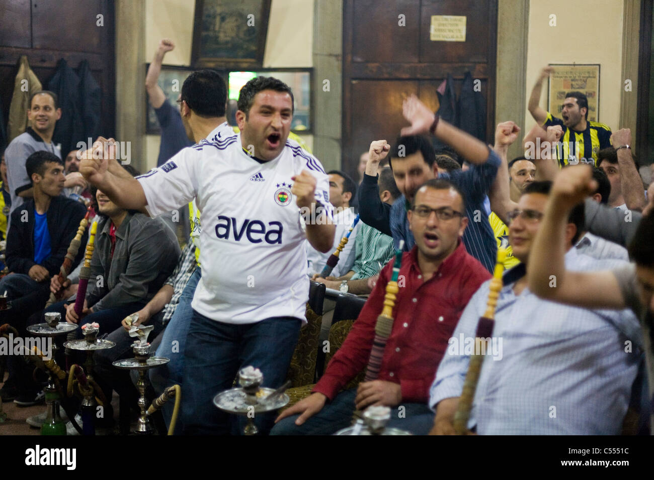 Fenerbahce fans cheering while watching the Turkish Superlig 2011 final on TV in Istanbul, Turkey Stock Photo