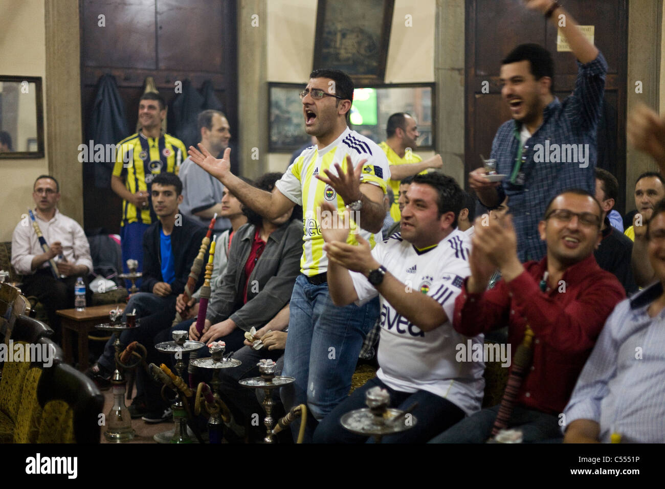 Fenerbahce fans cheering while watching the Turkish Superlig 2011 final on TV in Istanbul, Turkey Stock Photo