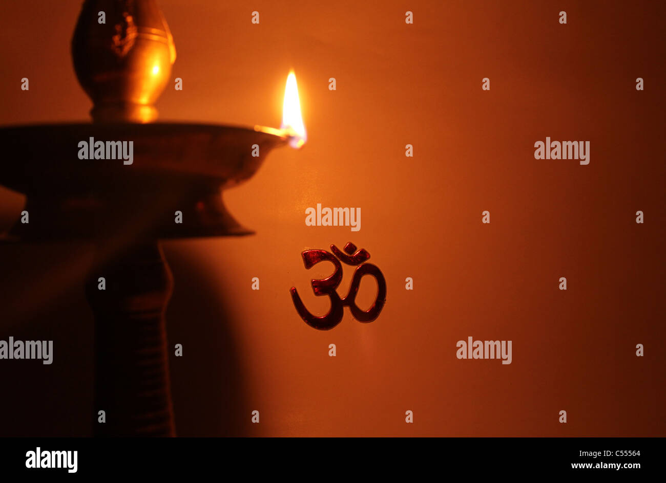 Hindu symbol 'om' or 'AUM' lit up by a traditional Indian lamp Stock Photo