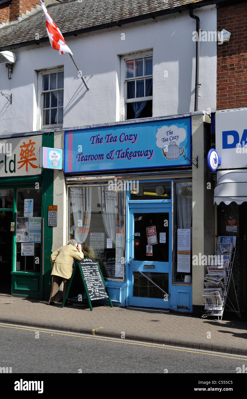 Tea shop in Christchurch, Dorset, with woman peering in the window