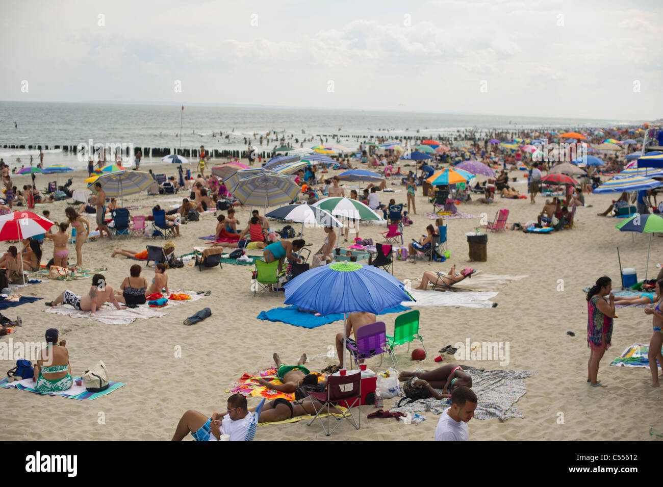 Beachgoers take advantage of the warm summer sun at Rockaway Beach in the Queens borough of New York Stock Photo