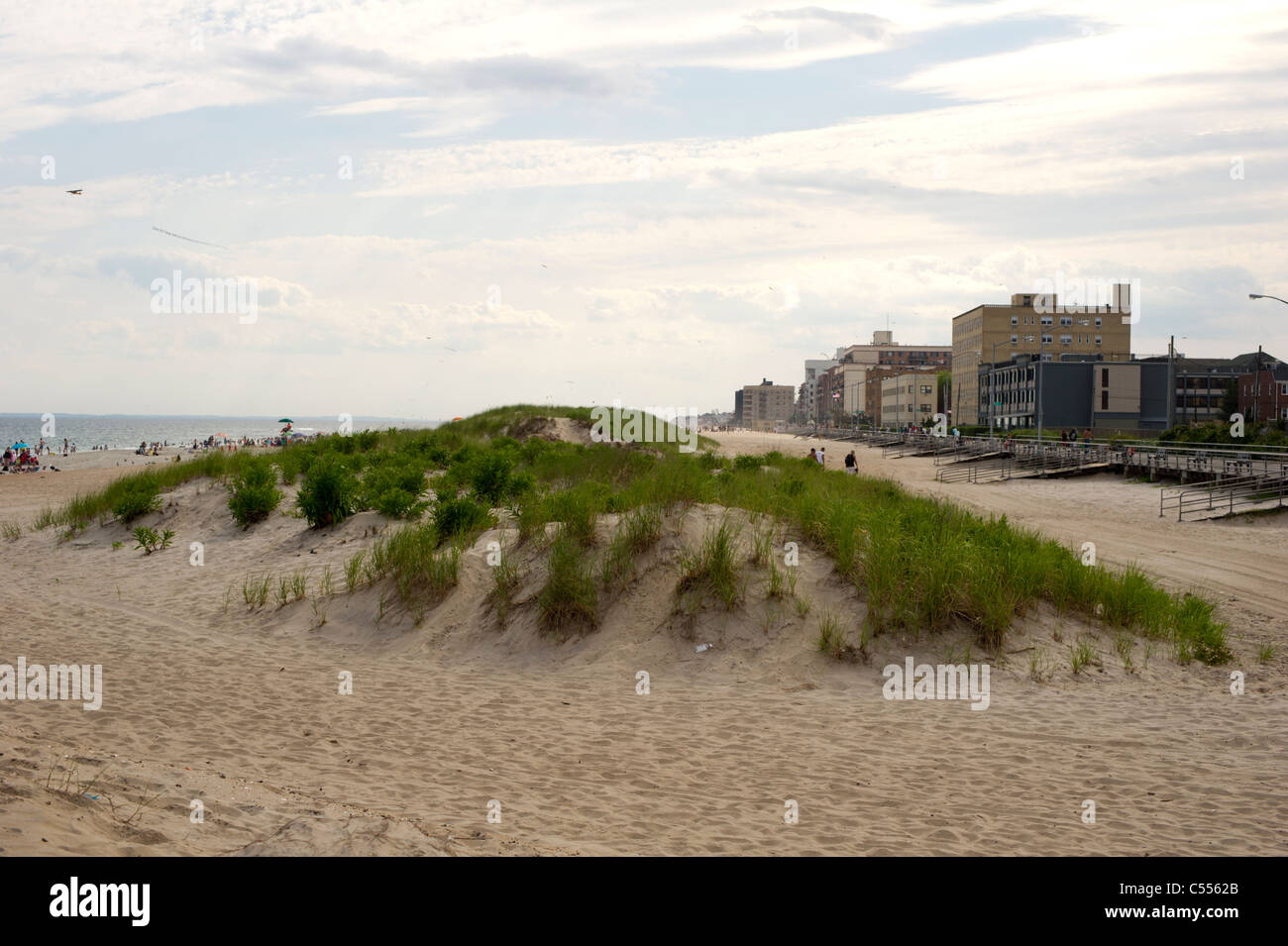 A sand dune in between the boardwalk and the beach at Rockaway Beach in the Queens borough of New York Stock Photo
