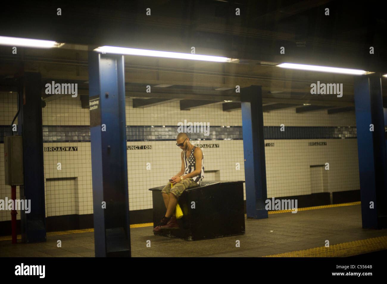 A straphanger waits for a subway train at the Broadway Junction station