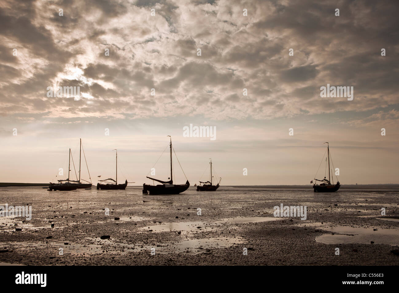 The Netherlands, Nes, Ameland Island, belonging to Wadden Sea Islands. Sailing boats on mud flat in harbour. Stock Photo