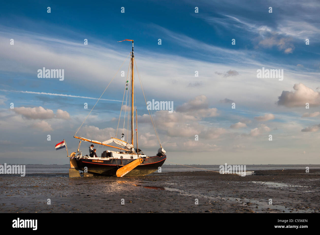 The Netherlands, Nes, Ameland Island, belonging to Wadden Sea Islands. Sailing boats on mud flat in harbour. Stock Photo