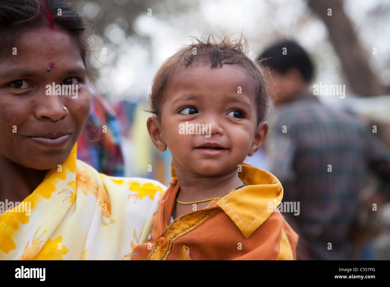 Close-up headshot facing view of smiling Indian mum carrying baby ...