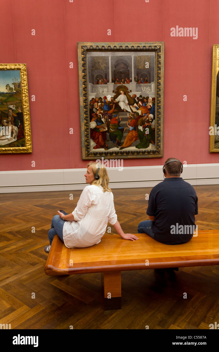 two people listening to audio guide at the Gemäldegalerie, Berlin, Germany Stock Photo