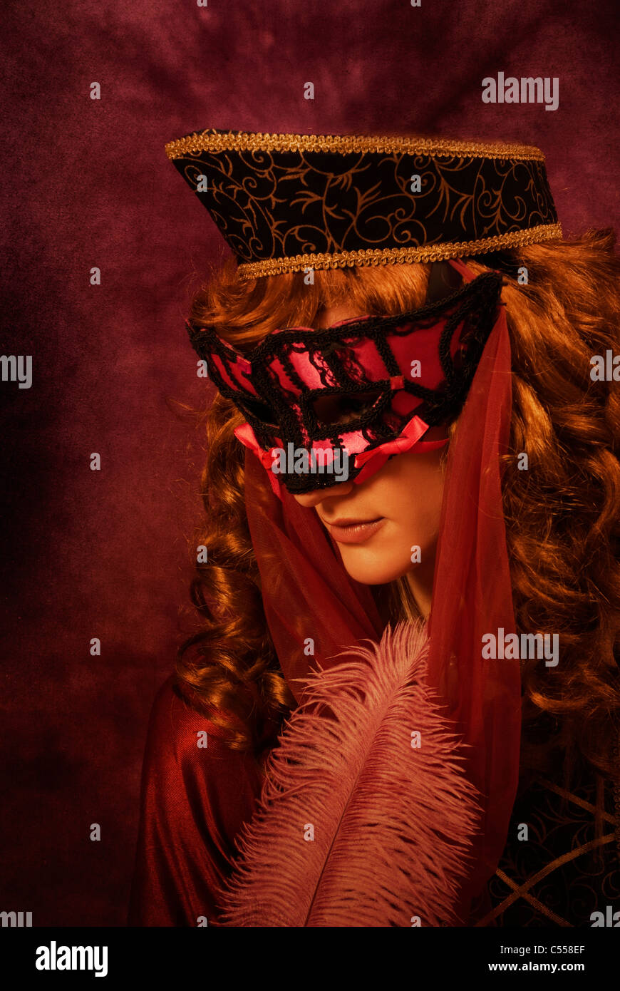 Medieval woman holding a feather and wearing a mask Stock Photo Alamy