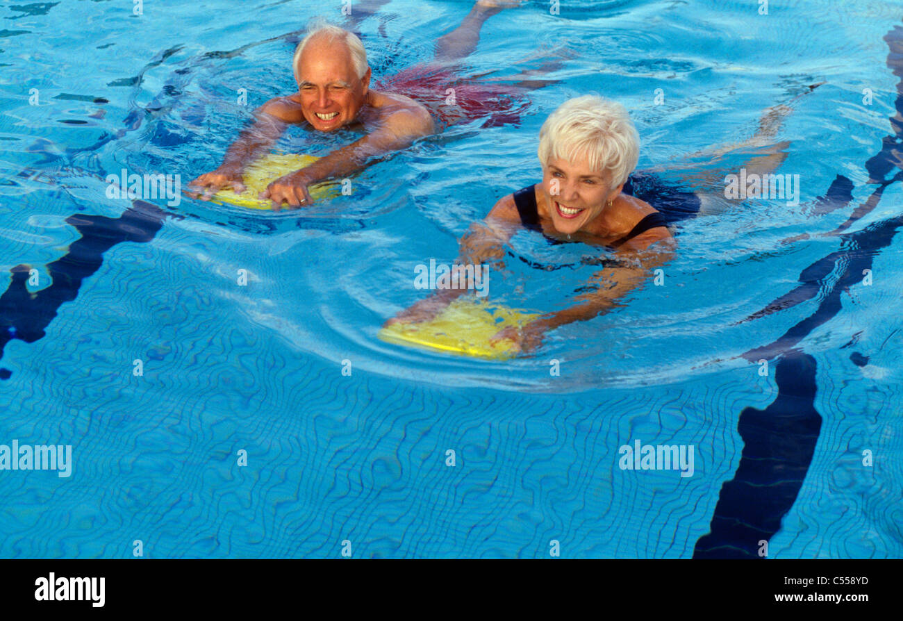 Senior couple swimming in swimming pool Stock Photo