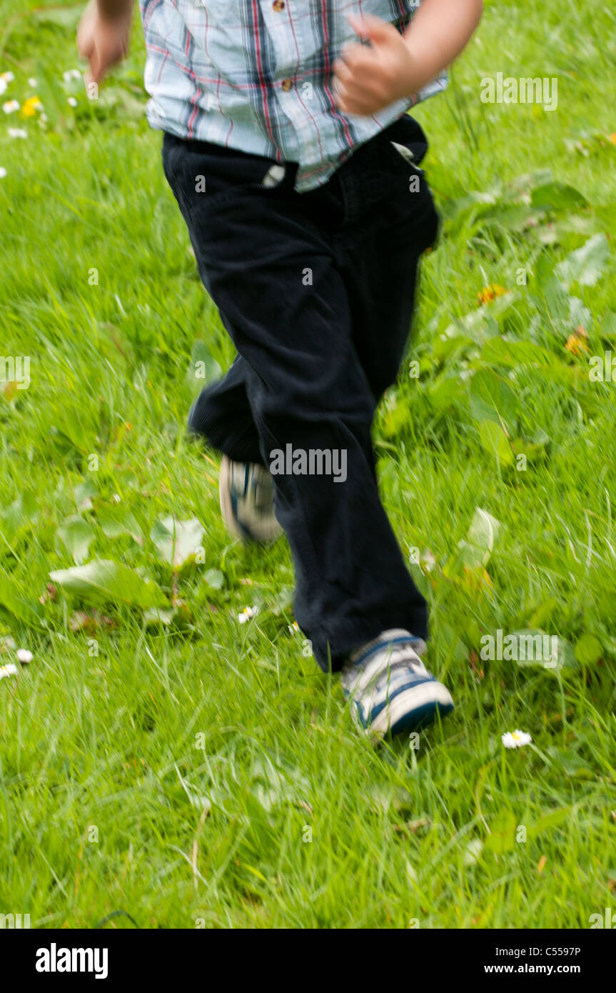 Blurred in motion , boy running in the field alone Stock Photo Alamy