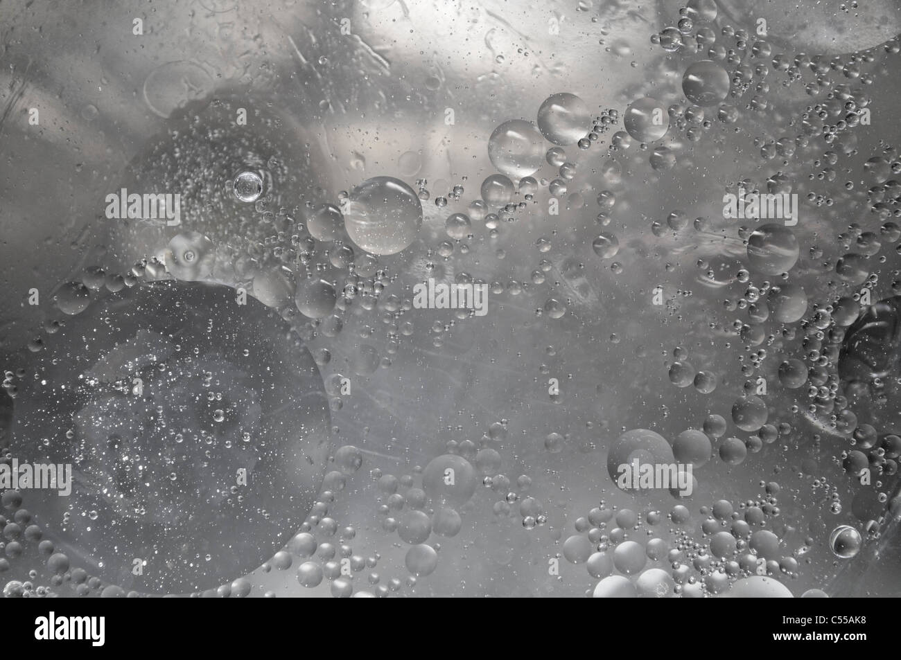 Almost colorless bubbles and drops randomly distributed in body of liquid Stock Photo
