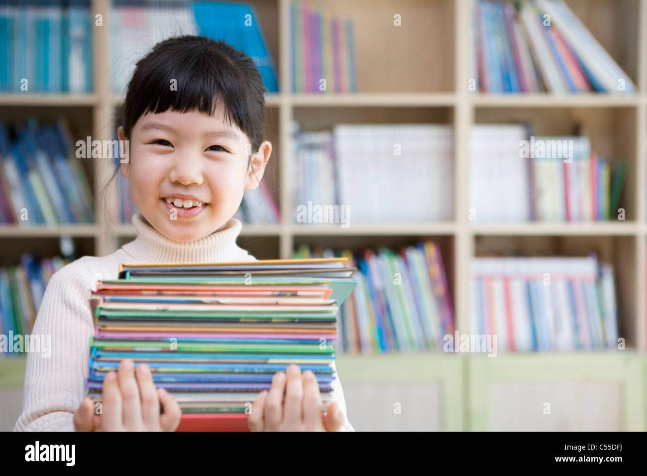 girl has books in her arms with a big smile Stock Photo - Alamy
