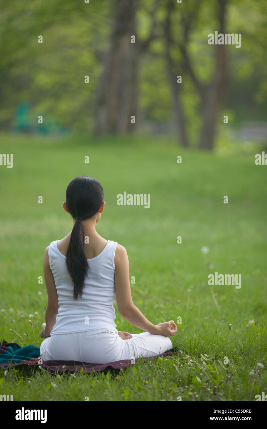 A woman doing Yoga on the grass Stock Photo - Alamy