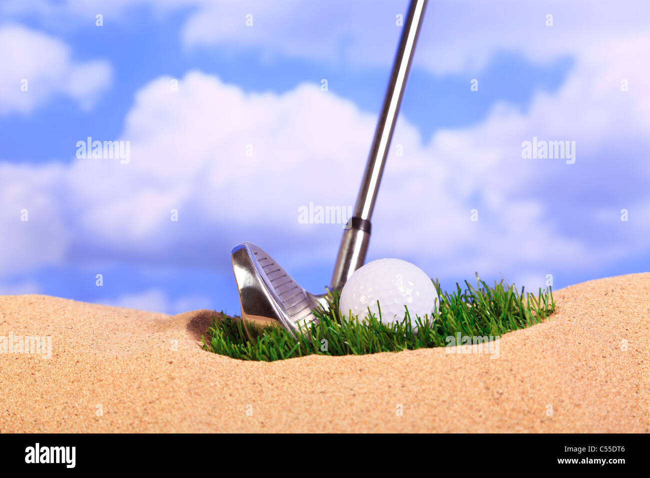 Golf concept photo of a ball lying on a patch of grass in a bunker. Stock Photo