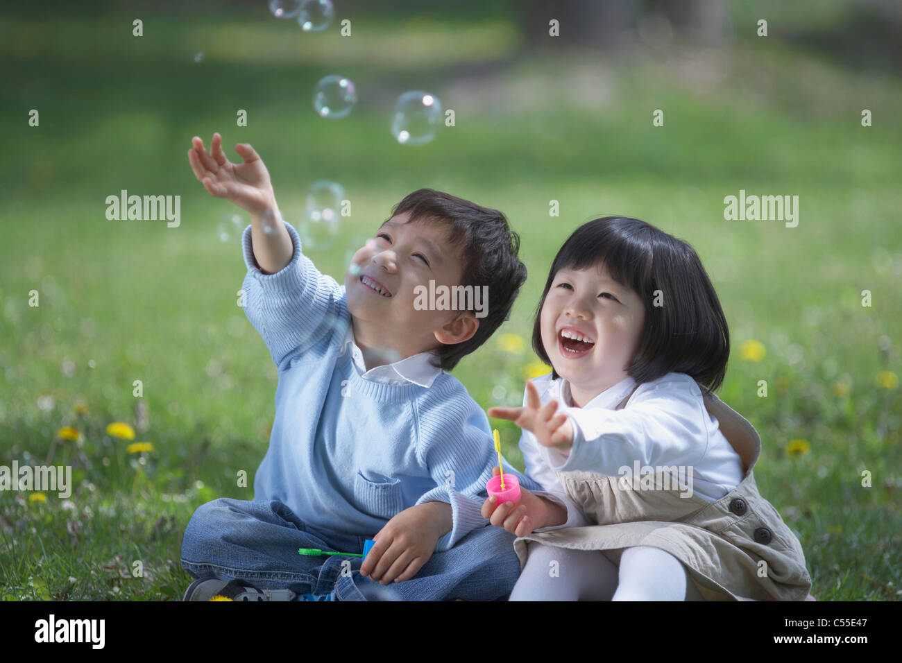 Two children playing with soap bubbles Stock Photo - Alamy
