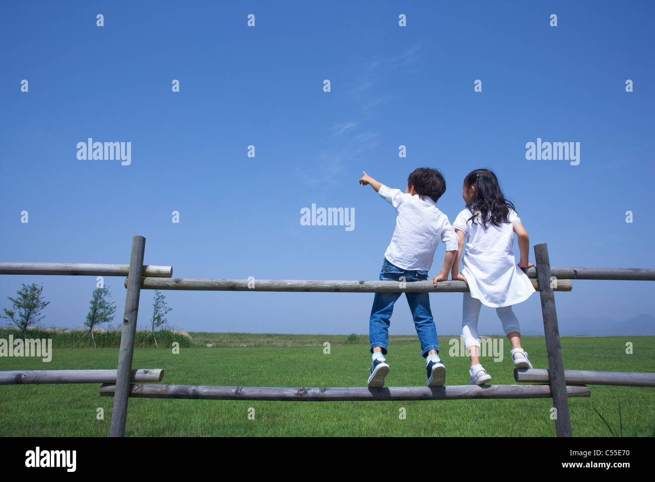 Children sitting on fence pointing hires stock photography and images Alamy