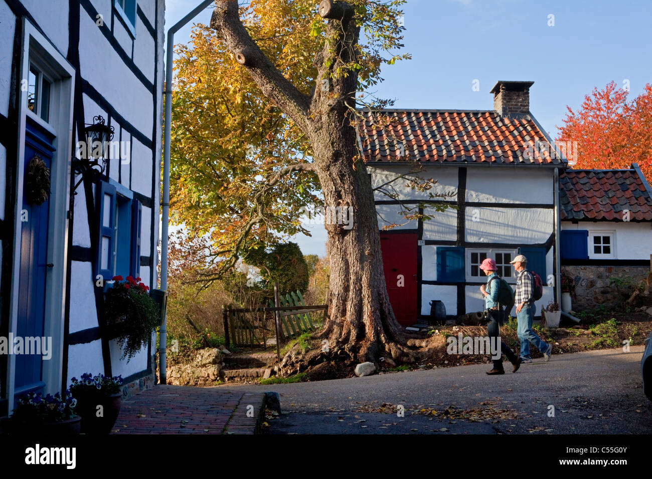 The Netherlands, Epen, Frame houses. Tourists hiking. Stock Photo