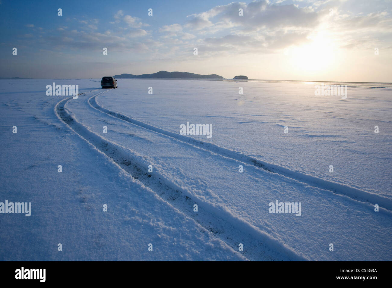 car makes wheel tracks on snow field Stock Photo - Alamy