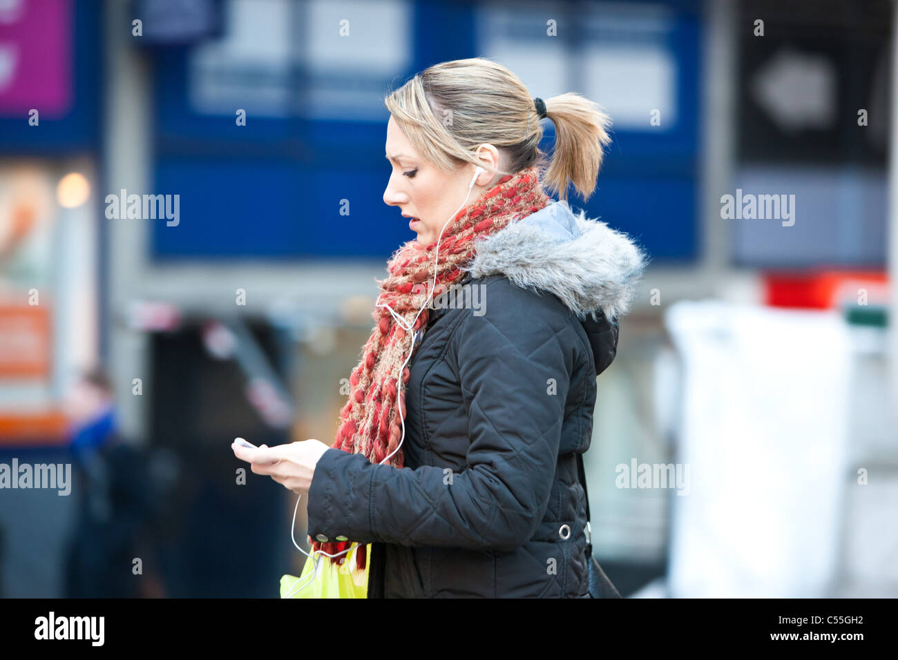 woman walking listening to music on mp3 player Stock Photo