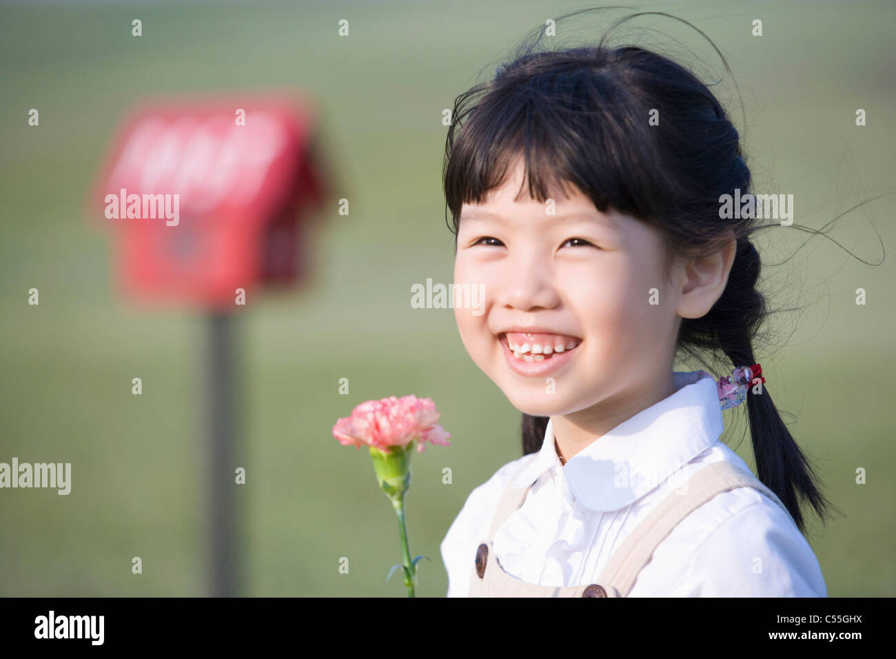 girl holding a flower with a smile Stock Photo - Alamy