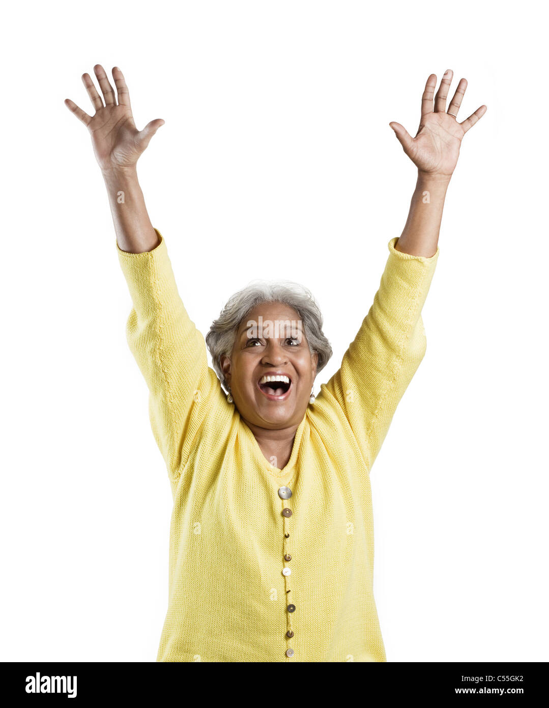 Senior woman standing with her arms raised and looking excited Stock ...