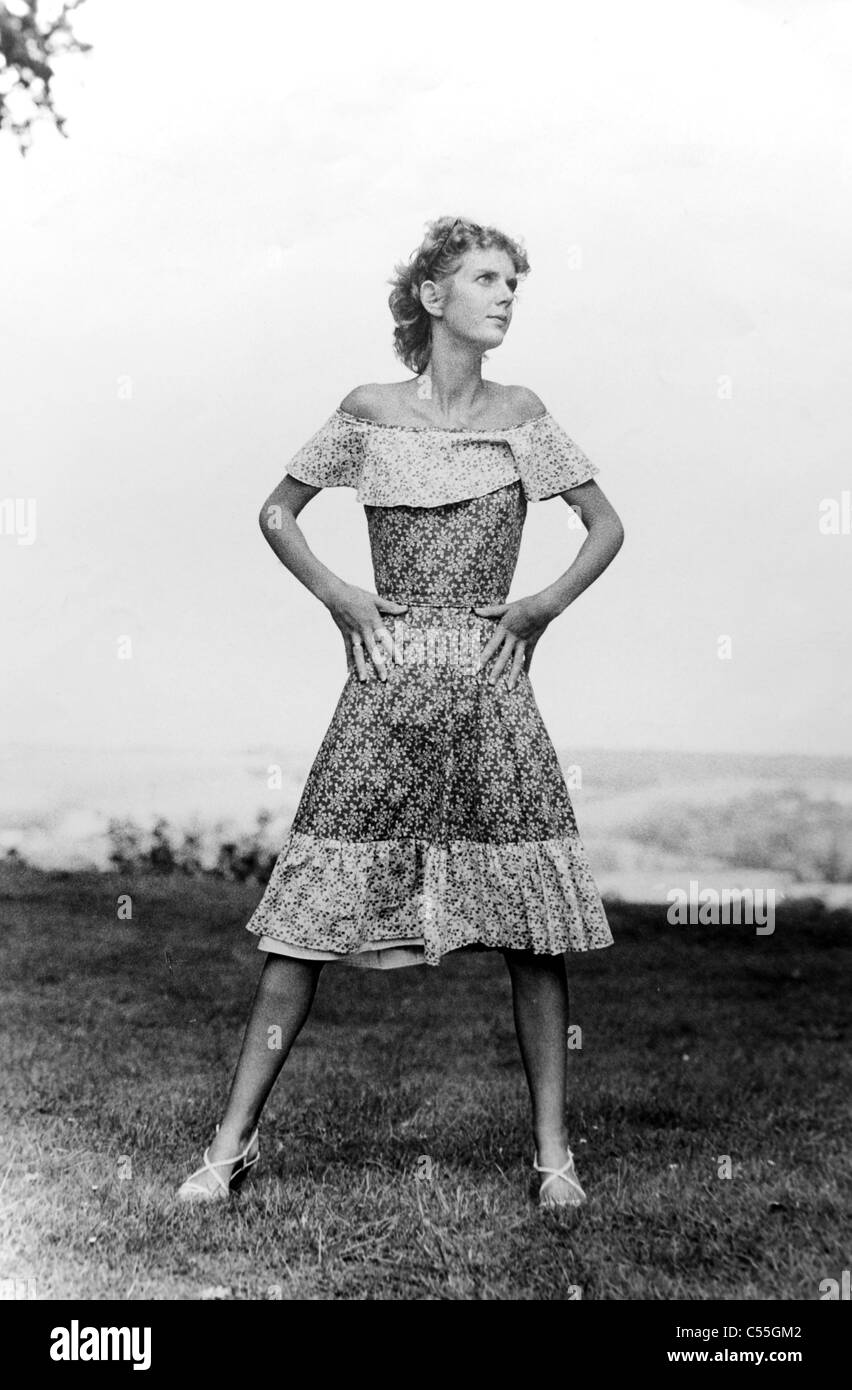 Young woman in her early 20s wearing knee length dress and skirt posing for fashion shoot in 1978 Stock Photo