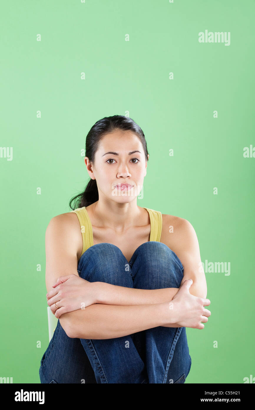 Young woman hugging her knees Stock Photo - Alamy