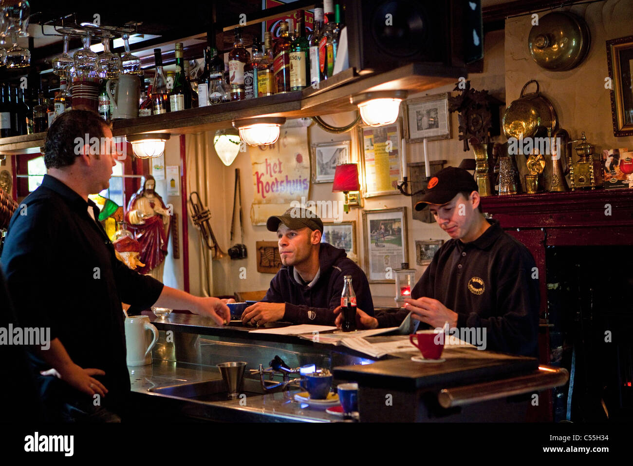 The Netherlands, Valkenburg, Barman talking with two boys in pub. Stock Photo
