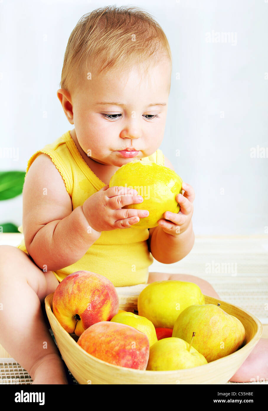 Little baby eating apple, closeup portrait, concept of health care