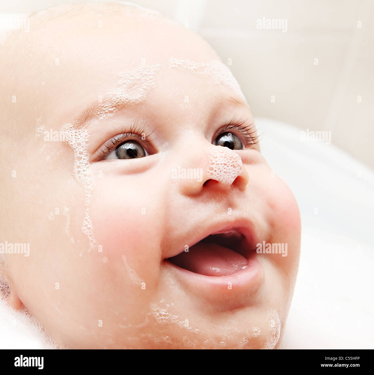 Little baby taking bath, closeup portrait of smiling boy, health care
