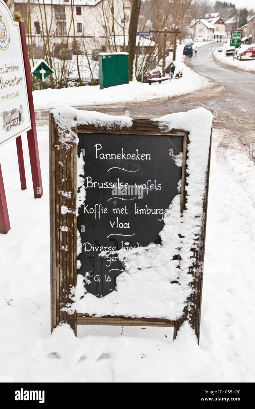 The Netherlands, Slenaken, Sign of outdoor cafe, covered with snow. Stock Photo