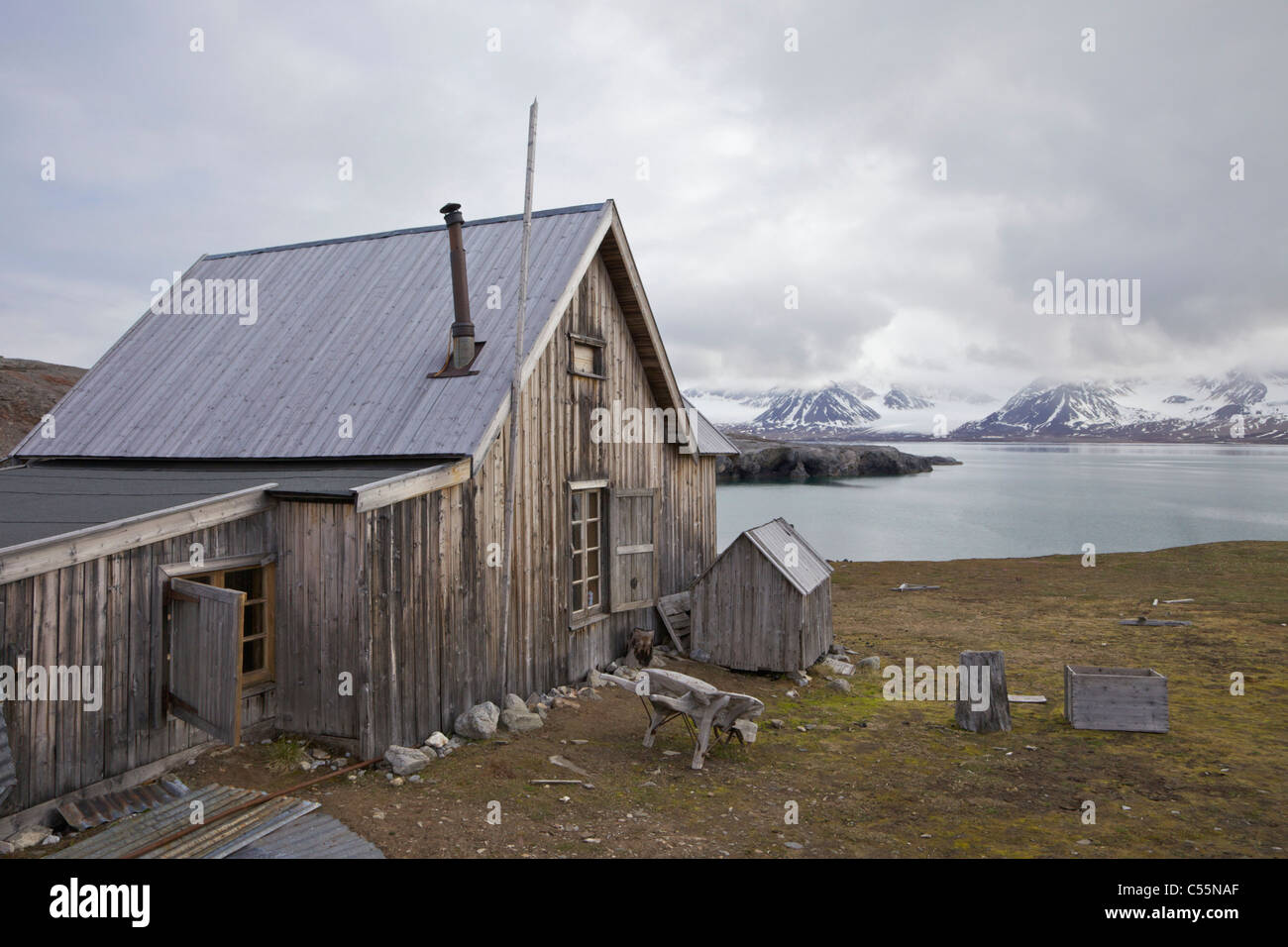 Old wooden trapper's hut on the coast, Camp Mansfield, Blomstrandhalvoya, Spitsbergen, Svalbard Islands, Norway Stock Photo