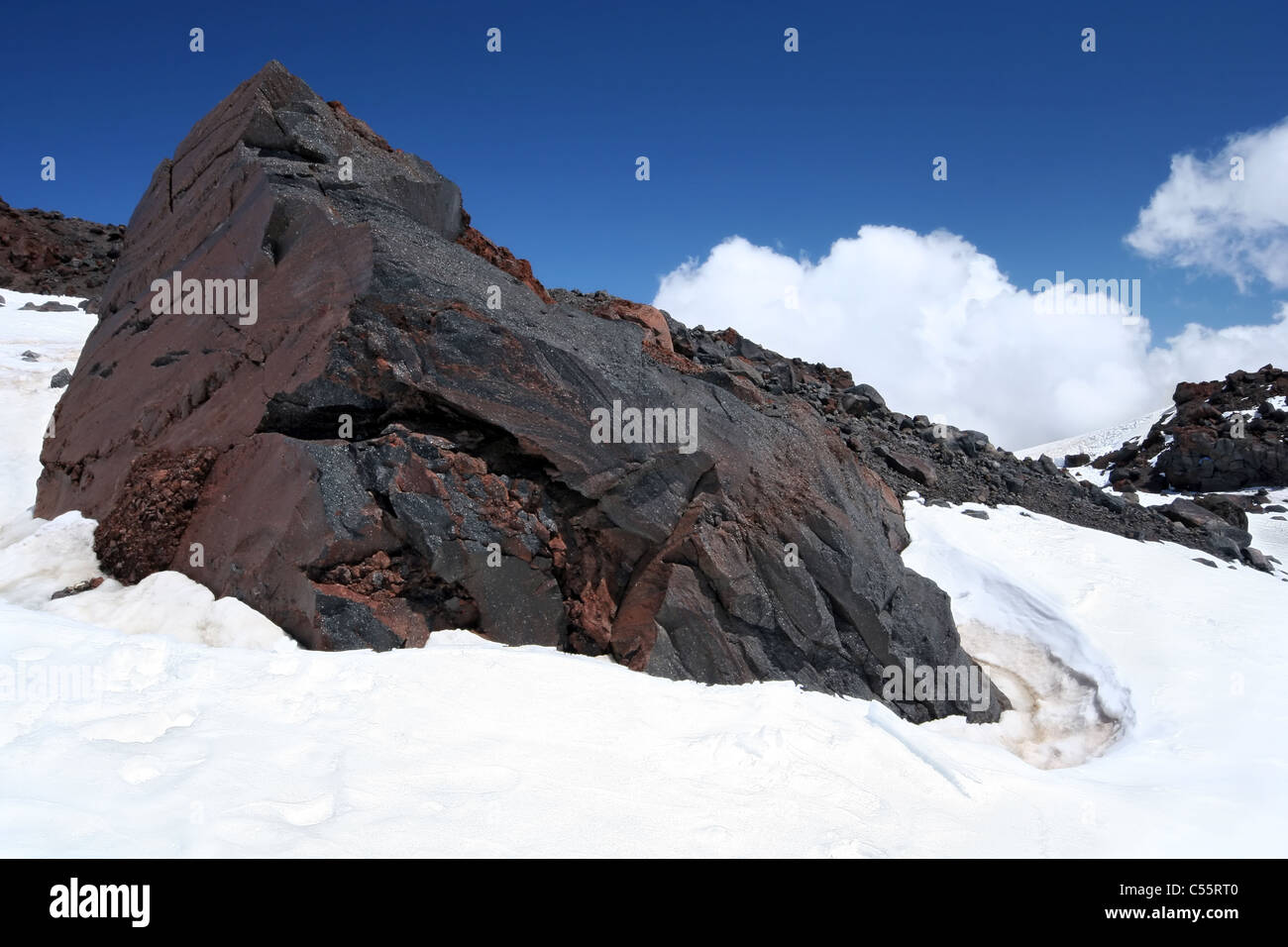 Huge rock (stone) among snow at the slope of the peak Elbrus. Caucasus. Russia. Stock Photo