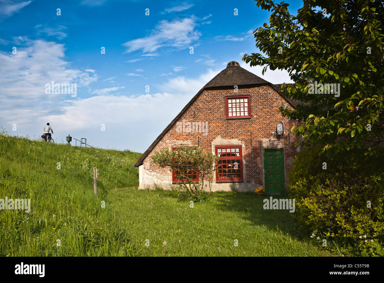 The Netherlands, Woudrichem, house near dike for protection against floods of Maas river. Stock Photo
