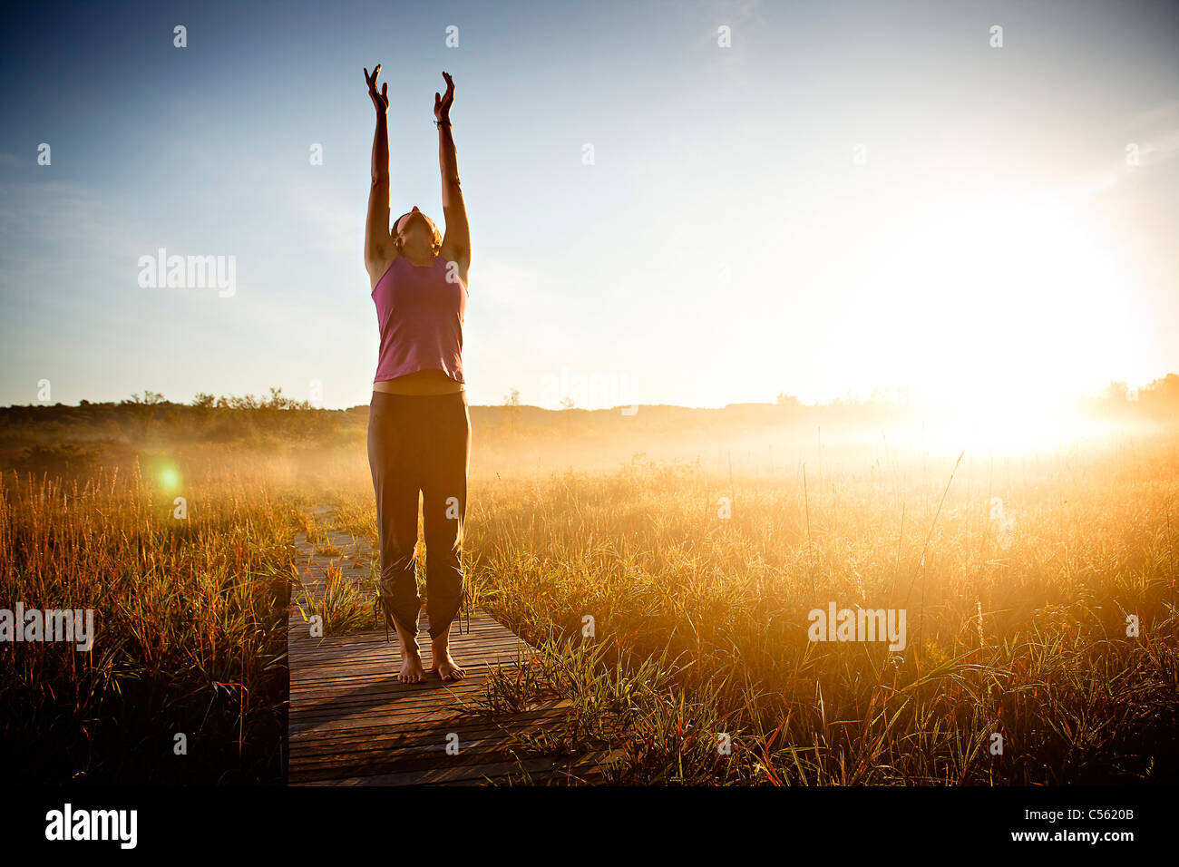 Woman meditating at a lake 30 35 years hires stock photography and