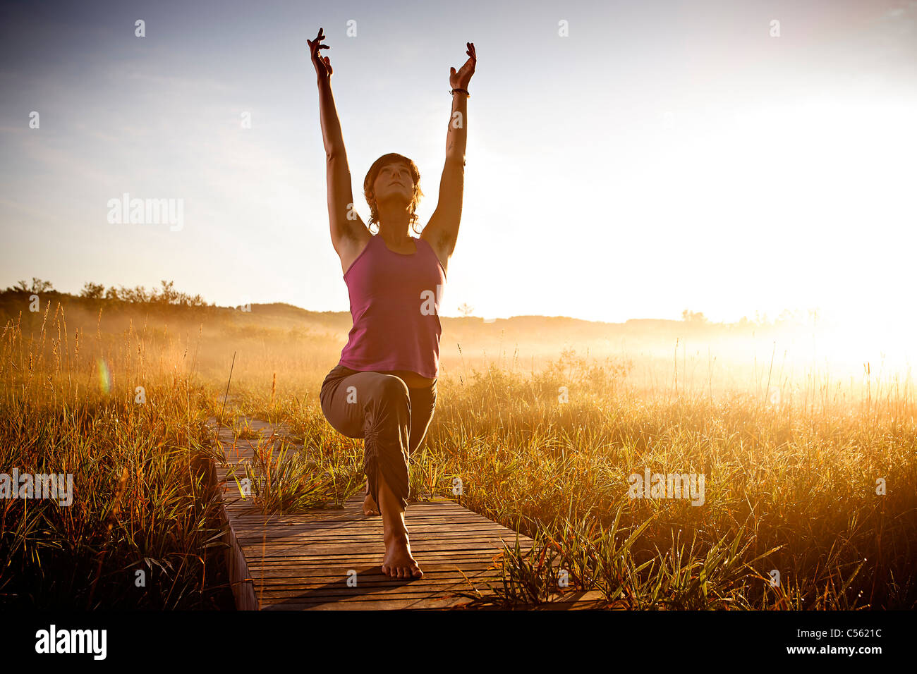 Woman meditating at a lake 30 35 years hires stock photography and