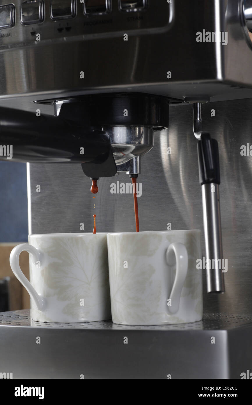 home espresso expresso coffee maker filling pair of cups Stock Photo