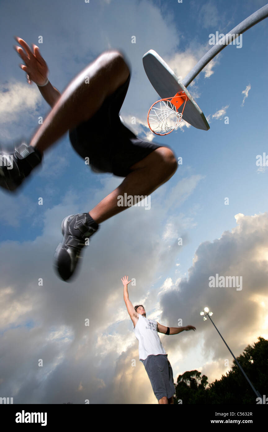 male scoring during outdoor basketball game, viewed from below Stock Photo