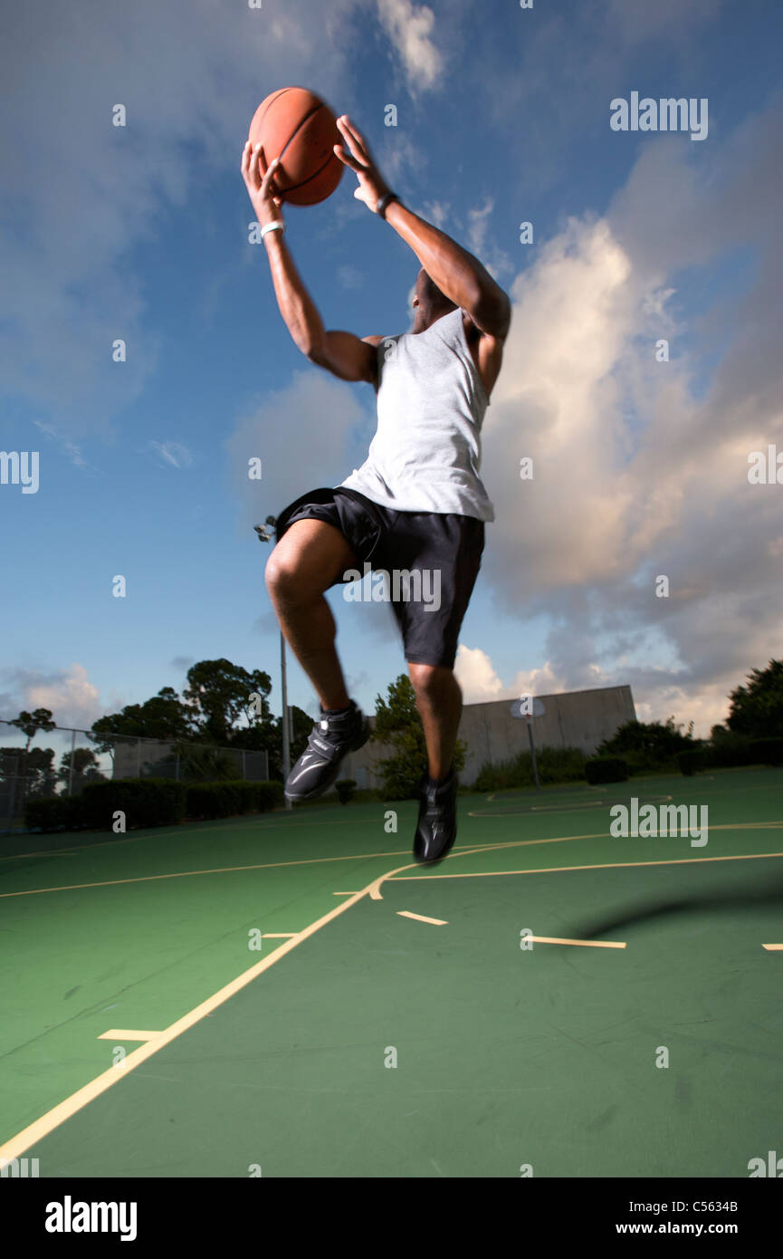male making vertical jump during outdoor basketball game Stock Photo