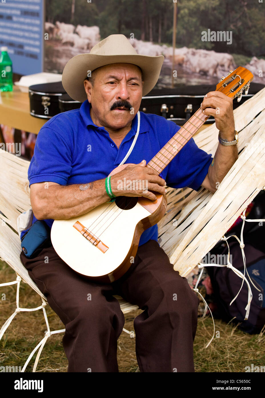 A South-American man wearing a cowboy hat strums a classical guitar Stock Photo