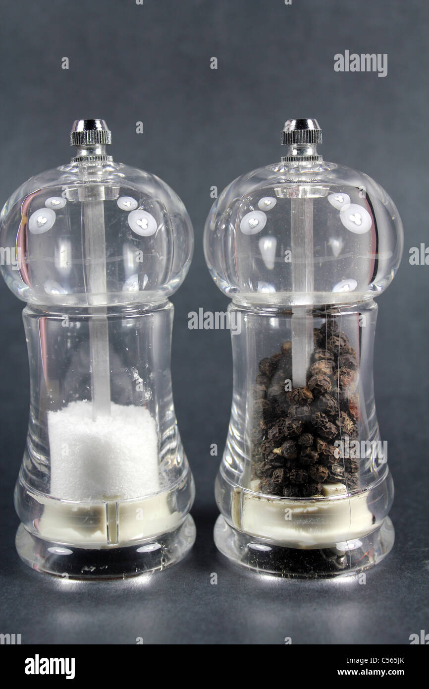 Salt and black pepper containers on black background Stock Photo Alamy