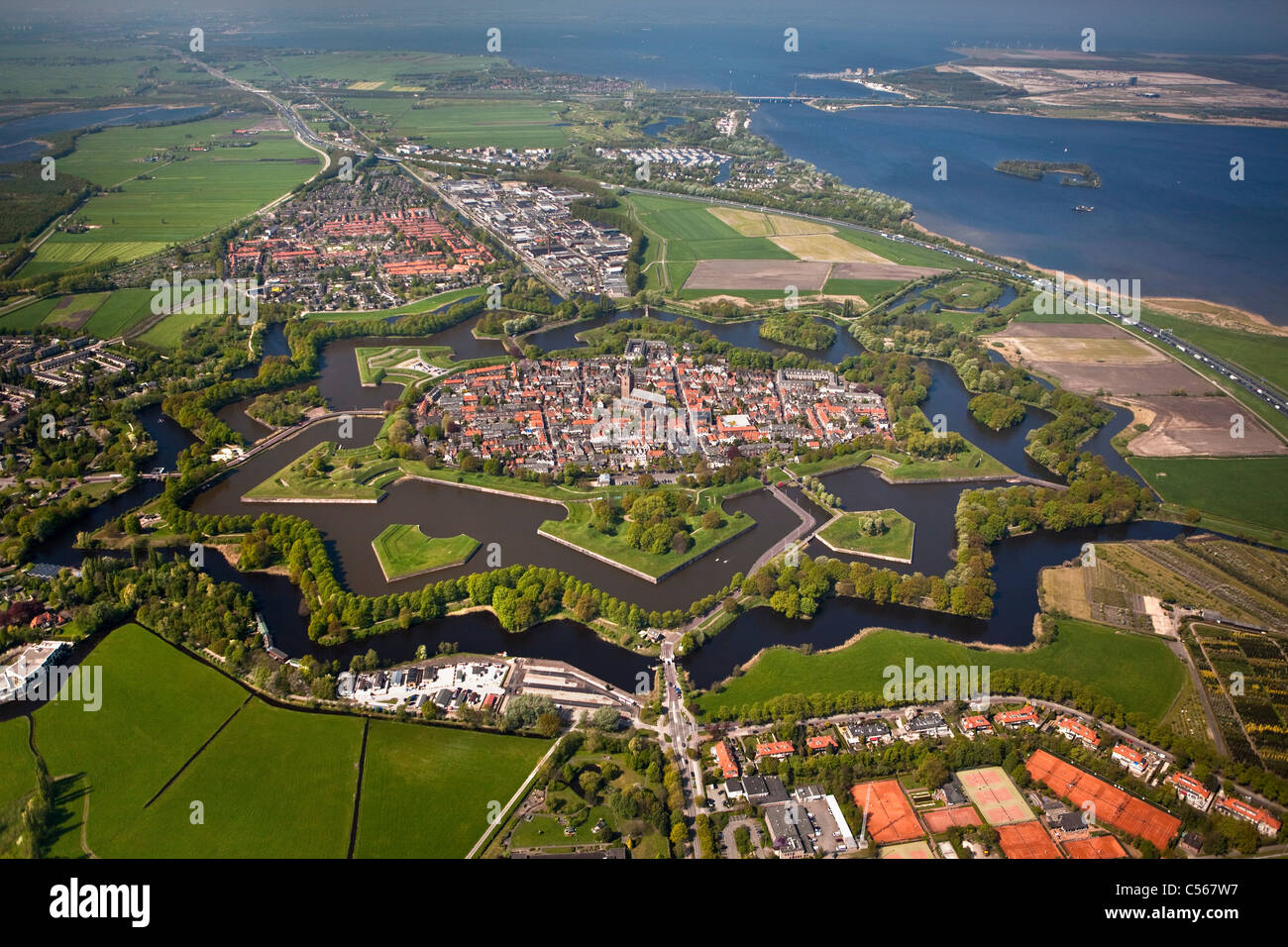 The Netherlands, Naarden, Star shaped fortressed village with canals, ramparts, bastions and ravelins. Aerial. Stock Photo