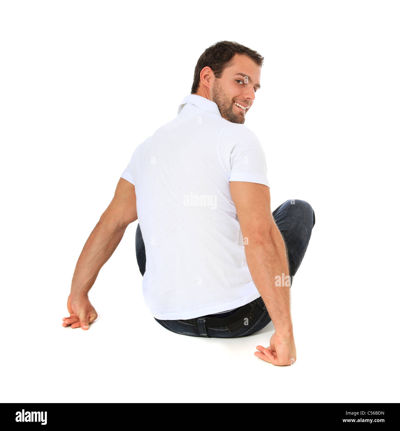 Full length shot of a young man sitting on the floor. All on white background. Stock Photo