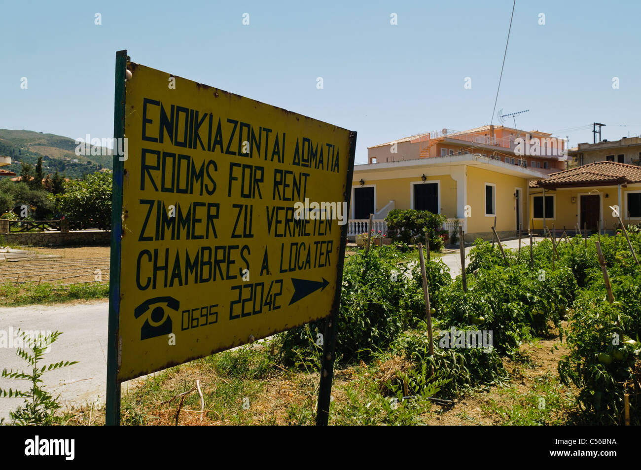 Multilingual sign advertising rooms for rent in Greek, English, German and French Stock Photo