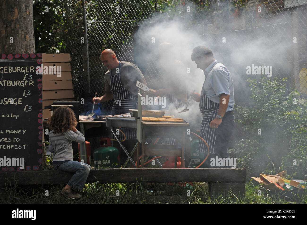 Lots of smoke as men cook on the BBQ at the Patchfest Community