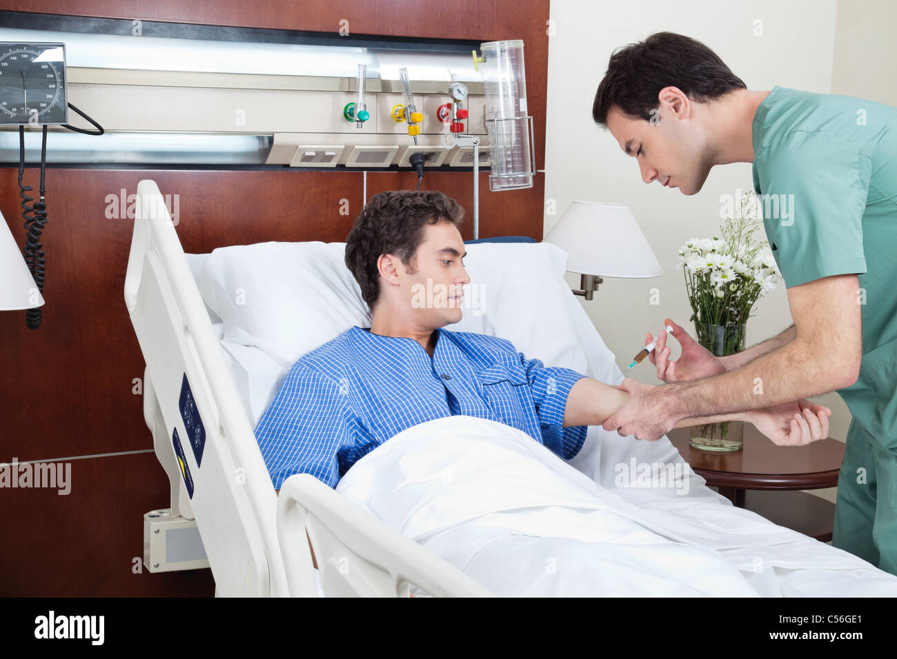 Doctor giving injection to the young patient in hospital Stock Photo